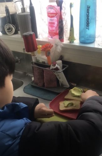 Issac making his avocado sandwich on his own